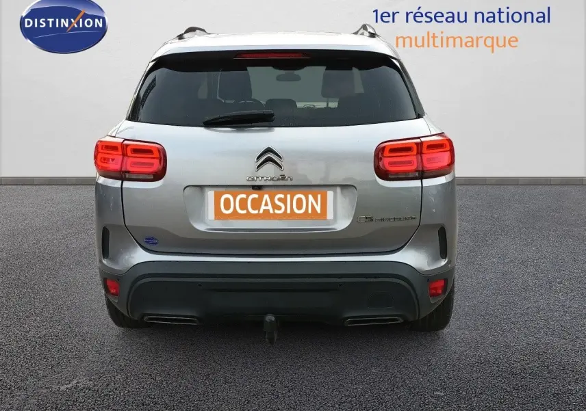 Vue arrière d'un Citroën C5 Aircross gris Artense métal avec feux LED allumés et attelage visible.