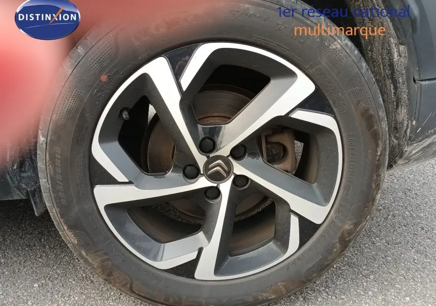 Gros plan sur la roue avant gauche avec jante alliage bicolore du Citroën C5 Aircross gris Artense 2020.