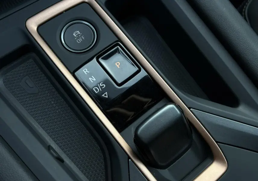 Gros plan sur la console centrale avec sélecteur de boîte auto et bouton de contrôle de traction du CUPRA Leon blanc.