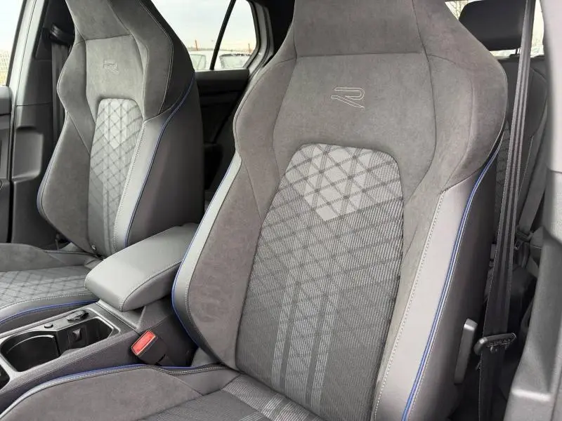 Gros plan sur les sièges avant gris avec surpiqûres bleues et logo R de la Volkswagen Golf 2.0 TDI R-Line 2026.