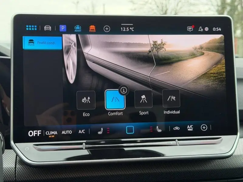 Écran tactile intérieur de la Volkswagen Golf 2.0 TDI R-Line 2026 montrant les modes de conduite avec vue partielle de la carrosserie blanche.