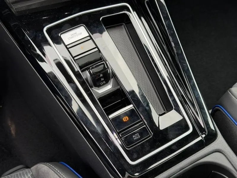 Gros plan sur la console centrale noire brillante de la Volkswagen Golf 2.0 TDI 150ch R-Line avec levier de vitesse électronique et bouton start/stop.