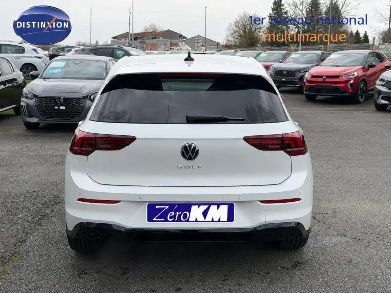 Vue arrière d'une Volkswagen Golf 2.0 TDI R-Line blanche oryx nacrée, avec vitres arrière teintées et feux LED sombres.