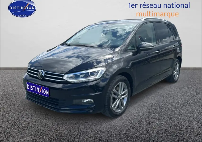 Volkswagen Touran noir vu en 3/4 avant droit, avec calandre chromée et jantes alliage visibles.