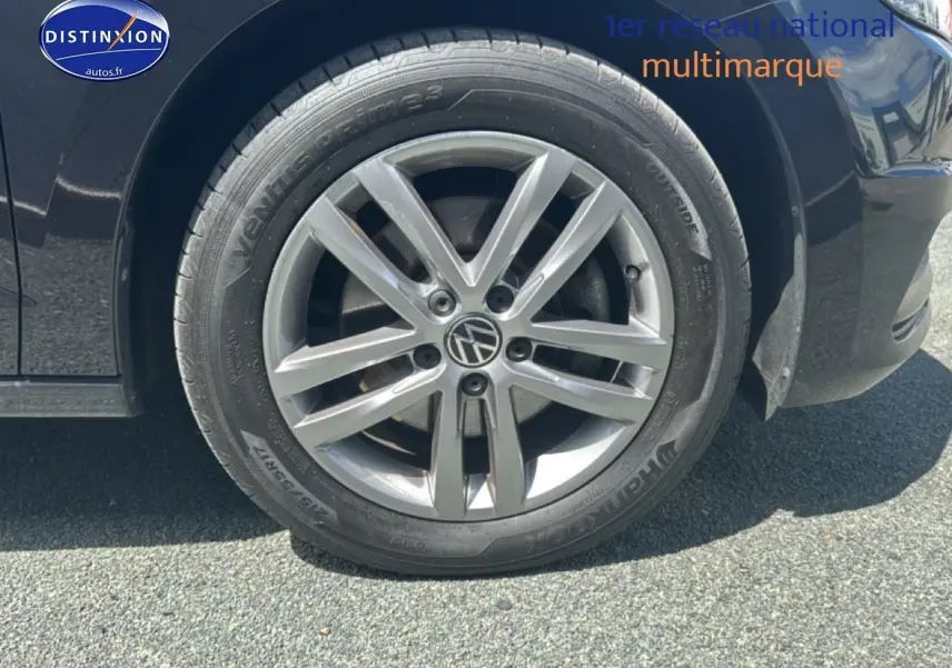 Gros plan sur la roue avant droite noire d'un Volkswagen Touran 2025 avec jante alu gris argenté.