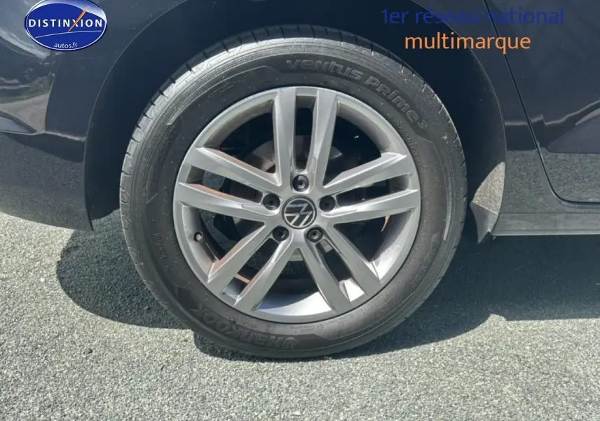 Gros plan sur la roue arrière droite avec jante alu argentée du Volkswagen Touran noir 2025.