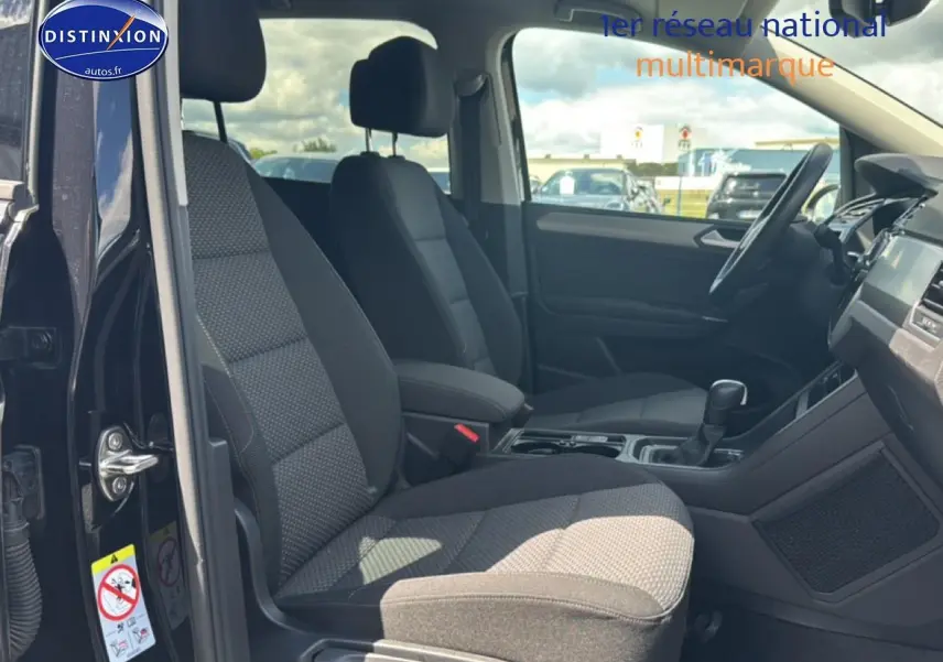 Vue intérieure côté conducteur du Volkswagen Touran noir 2025, mettant en valeur les sièges avant et le tableau de bord.