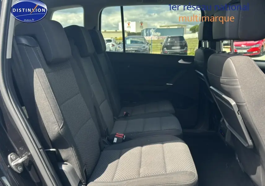Vue latérale gauche sur la deuxième rangée de sièges noirs du Volkswagen Touran 2025 avec 7 places et intérieur spacieux.
