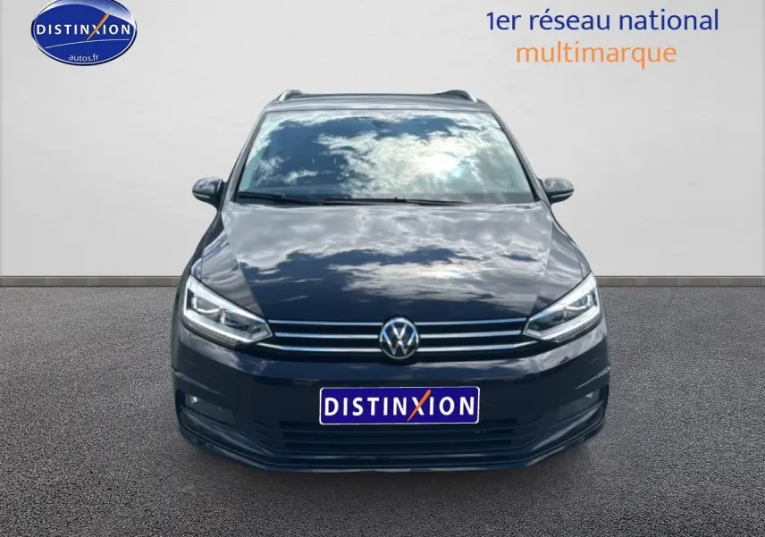 Vue de face du Volkswagen Touran noir 2025 avec calandre chromée et phares LED allumés.