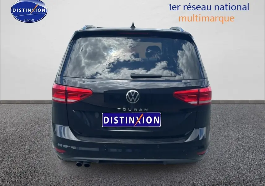 Vue arrière d’un Volkswagen Touran noir 2025 avec feux rouges et double sortie d’échappement visible.