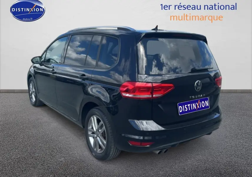 Volkswagen Touran noir vu en 3/4 arrière droit, avec vitres surteintées et jantes alu visibles.