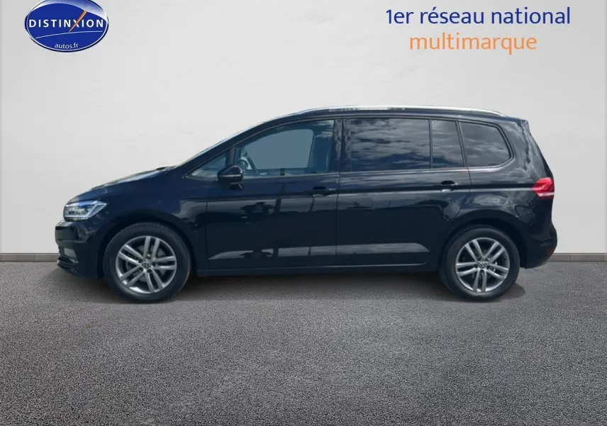 Profil côté gauche du Volkswagen Touran noir 2025 avec jantes alu et vitres arrière surteintées.