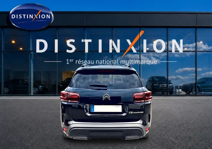 Vue arrière d'un Citroën C5 Aircross noir 2025, avec feux LED et barres de toit visibles devant une vitrine Distinxion.