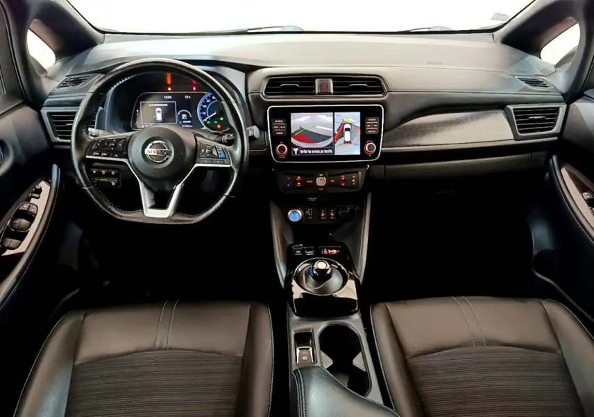 Vue intérieure avant du Nissan Leaf 62 kWh avec tableau de bord noir et écran tactile central affichant la caméra 360°