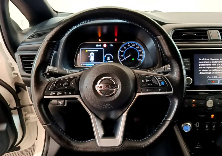 Vue rapprochée du volant cuir noir de la Nissan Leaf 62 kWh 2020 avec tableau de bord numérique et écran tactile.