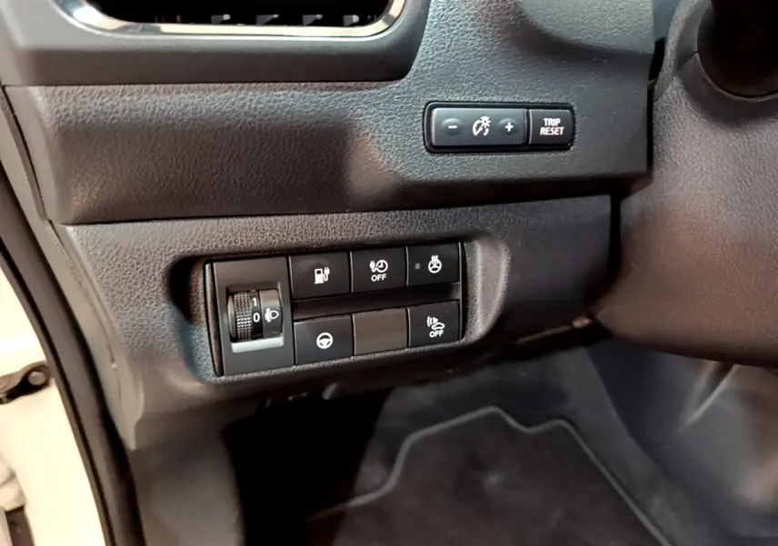 Gros plan sur les commandes de réglage et d'assistance côté conducteur du tableau de bord noir du Nissan Leaf blanc 2020.