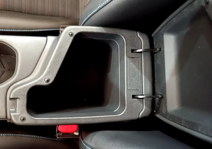 Vue plongeante sur le rangement central ouvert avec coutures bleues sur les sièges du Nissan Leaf blanc 2020 Business+