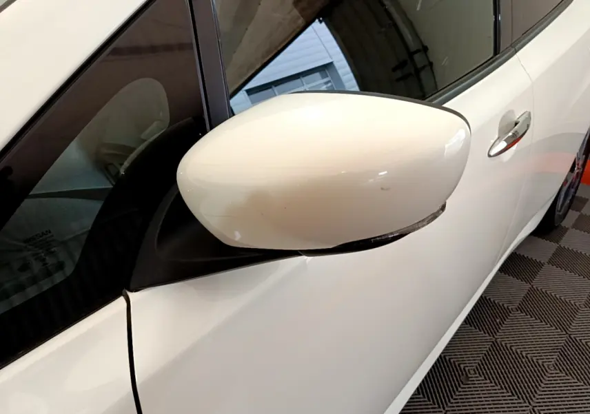 Rétroviseur côté gauche blanc de la Nissan Leaf 62 kWh Business+ 2020, avec poignée de porte visible.