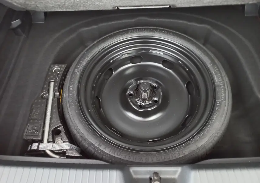 Roue de secours noire et cric dans le coffre d'une Volkswagen Golf 2.0 TDI 150 DSG7 Style 2024 Rouge Roi