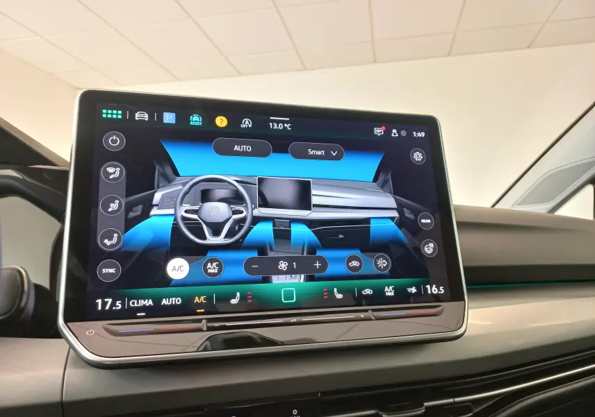 Écran tactile central affichant la climatisation et le volant multifonction de la Volkswagen Golf Rouge Roi 2024