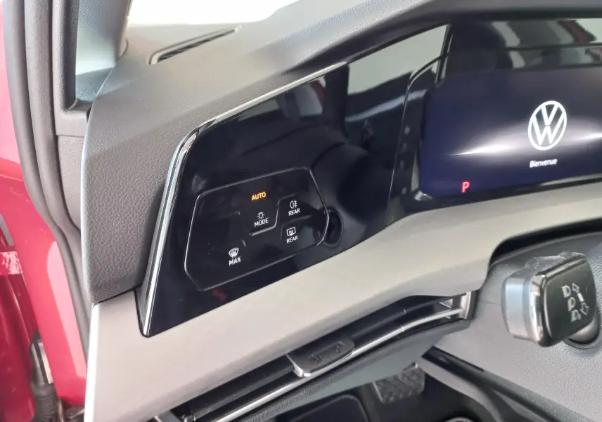 Détail du tableau de bord d'une Volkswagen Golf 2.0 TDI 150 DSG7 Style rouge, avec commandes d'éclairage et écran digital.