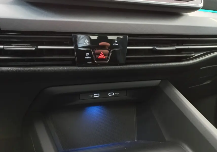 Détail de la console centrale de la Volkswagen Golf 2.0 TDI 150 DSG7 Style 2024 avec commandes d'assistance, climatisation et ports USB éclairés.