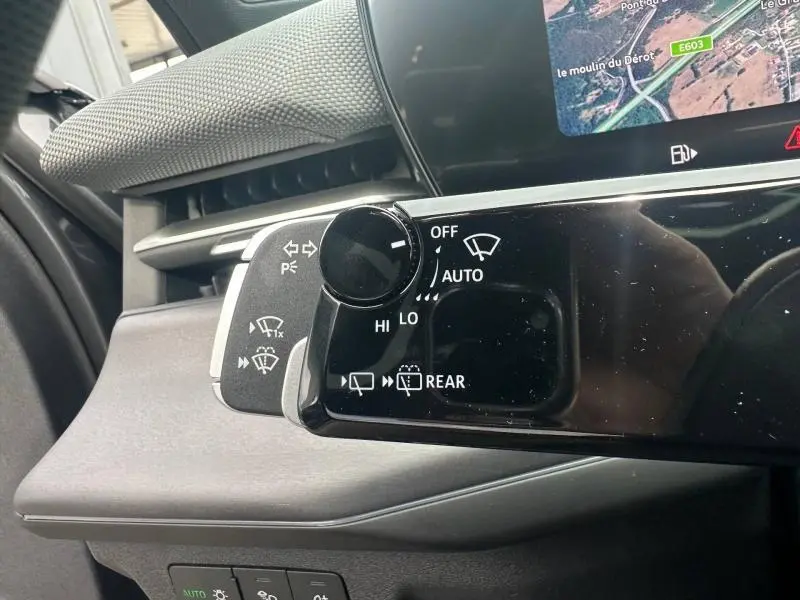 Gros plan sur la commande d’essuie-glace côté gauche de l’Audi Q3 gris 2026 avec affichage partiel de l’écran multimédia.