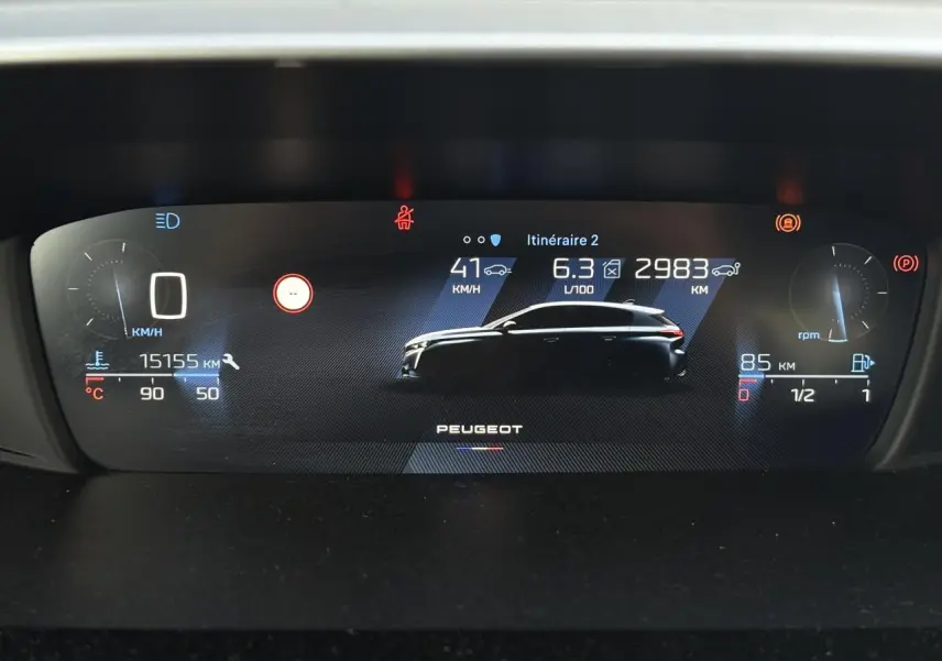 Combiné numérique 10 pouces de Peugeot 308 2024 affichant vitesse, consommation et autonomie avec silhouette du véhicule en profil.