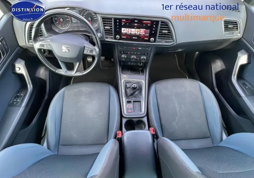 Vue intérieure avant du SEAT Ateca 2019 avec sellerie textile bleu, volant cuir multifonction et écran tactile central.