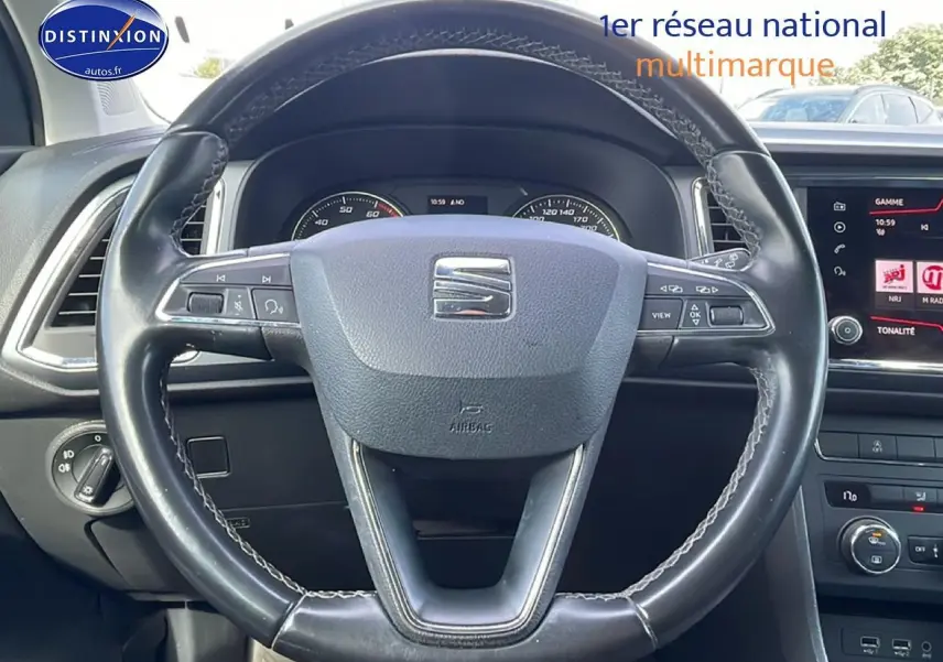 Vue rapprochée du volant cuir noir du SEAT Ateca 2019 avec tableau de bord et écran tactile visibles.