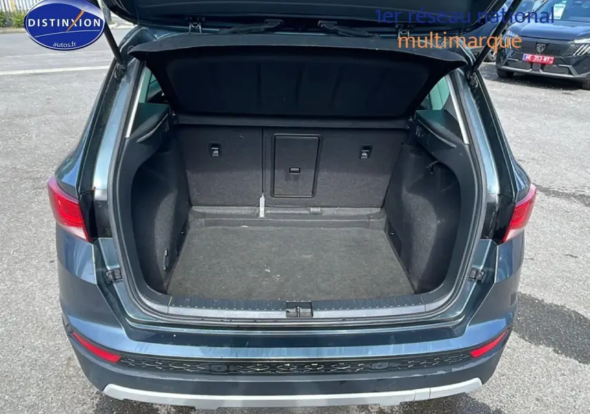 Coffre ouvert vu de l'arrière d'un SEAT Ateca bleu/gris 2019, montrant un espace de chargement vide.