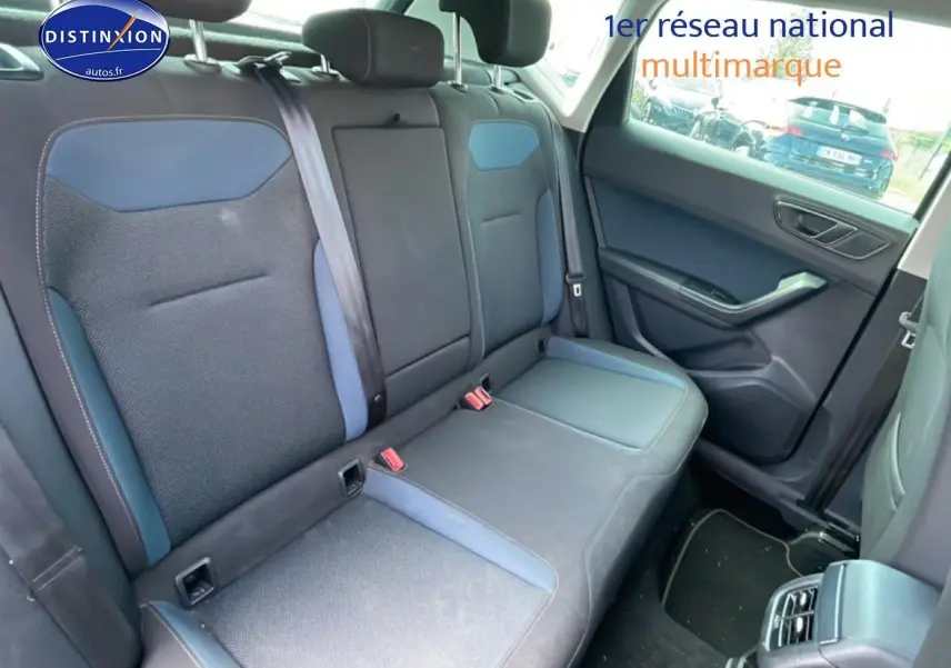 Vue intérieure côté arrière droit montrant la banquette textile bleu et gris du SEAT Ateca 2019 avec accoudoir central.