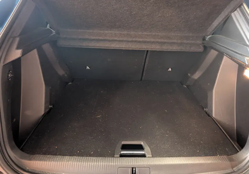 Coffre ouvert vu de l'arrière d'un Peugeot 2008 bleu, montrant un espace de chargement propre et spacieux.