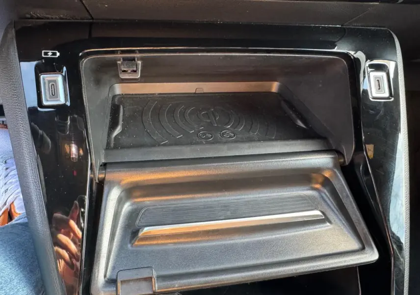 Gros plan sur la console centrale noire du Peugeot 2008 Hybrid 136 e-DCS6 Allure avec compartiment de rangement ouvert.