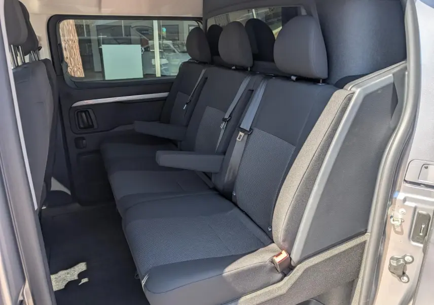 Vue latérale intérieure sur la banquette arrière 3 places en tissu bi-ton gris du Peugeot Expert Fourgon gris.