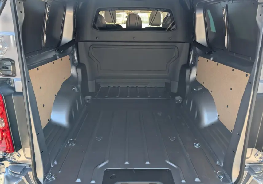 Vue intérieure de l'espace de chargement du Peugeot Expert Fourgon XL gris, avec cloison pleine et panneaux latéraux en bois.