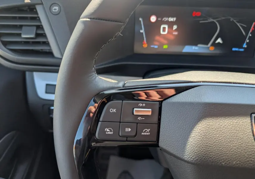 Gros plan sur le volant cuir gris du Peugeot Expert Fourgon 2026 avec commandes multifonctions et combiné numérique en arrière-plan.