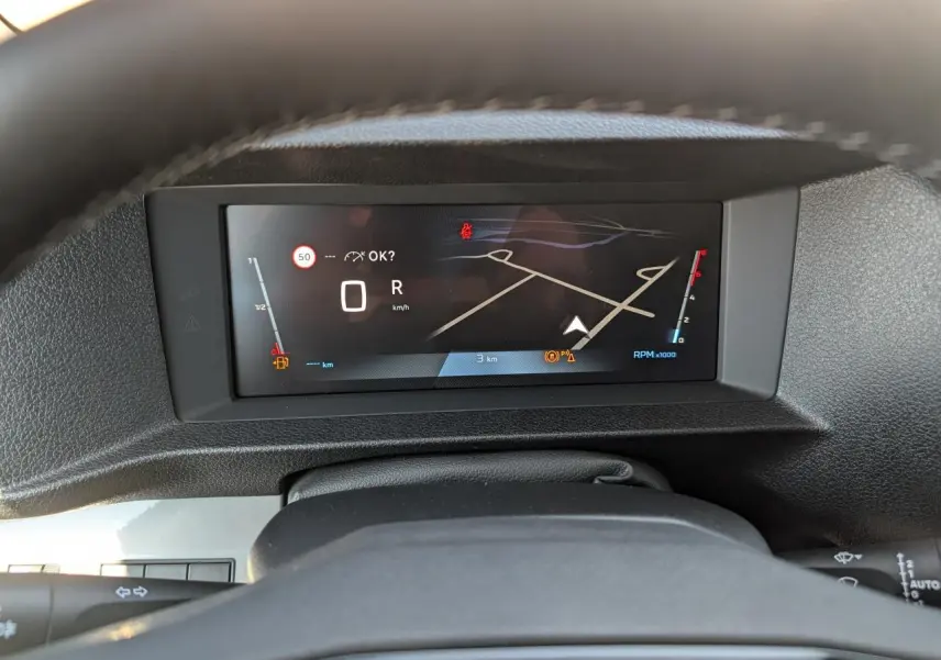 Vue rapprochée du combiné numérique 10 pouces affichant la navigation et les informations de vitesse du Peugeot Expert Fourgon gris.