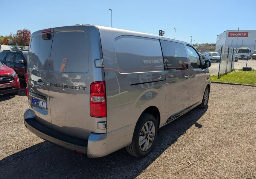 Vue 3/4 arrière droit d'un Peugeot Expert Fourgon gris métallisé avec jantes alliage 17'' et portes arrière tôlées ouvertes.