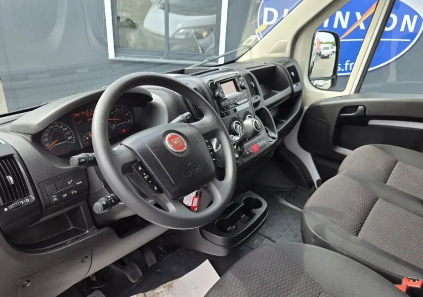 Intérieur du FIAT Ducato Fourgon blanc 2023, vue côté conducteur sur le tableau de bord et volant multifonctions.