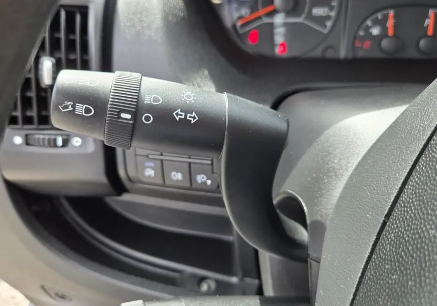 Gros plan sur la manette de clignotant et phare du tableau de bord noir du Fiat Ducato Fourgon 2023.