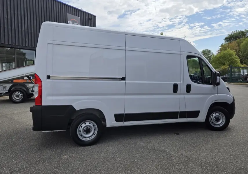 Fiat Ducato Fourgon blanc vu de profil côté gauche, avec porte latérale coulissante et jantes acier.