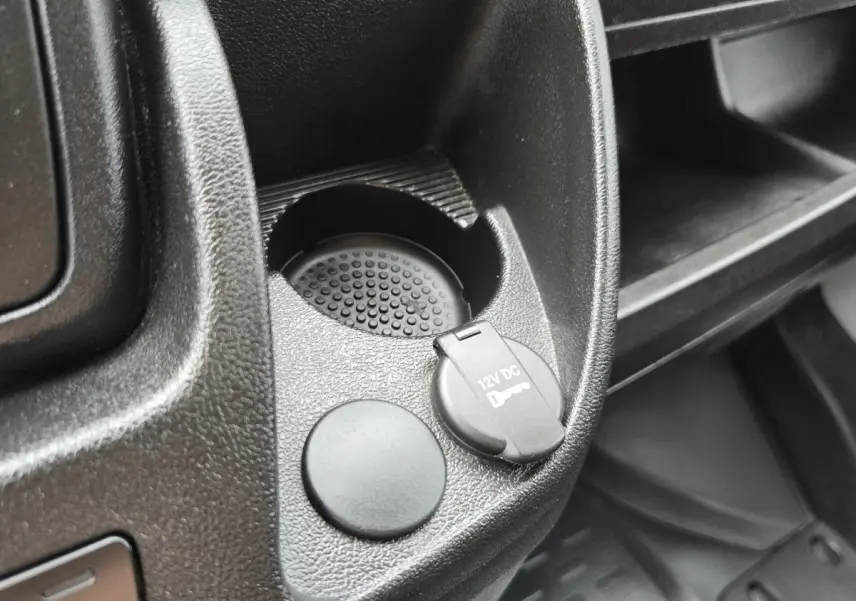 Gros plan sur la prise 12V et porte-gobelet dans l’habitacle noir du Fiat Ducato Fourgon blanc.