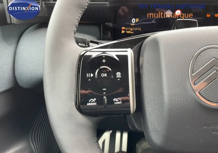 Gros plan sur le volant gris du Citroën C5 Aircross 2026, montrant les commandes multifonctions à gauche et le logo Citroën central.