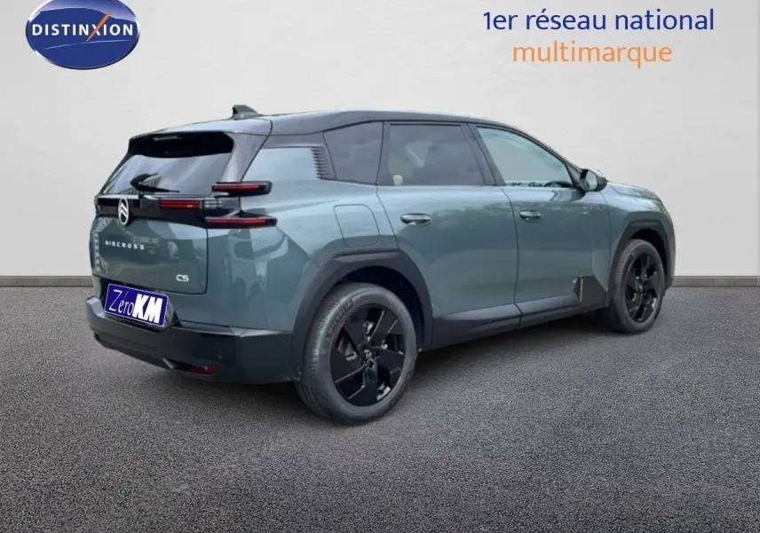 Vue 3/4 arrière droite d'un Citroën C5 Aircross 2026 vert Astoria métallisé avec jantes noires et toit noir.