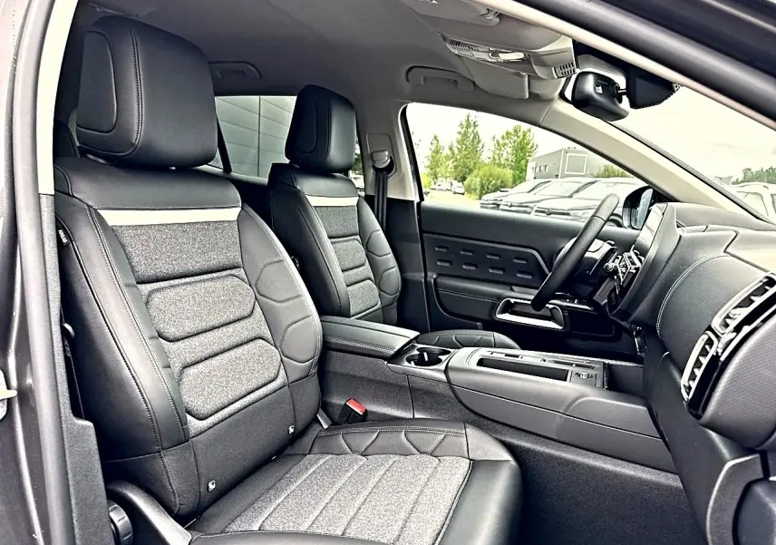 Vue intérieure côté conducteur du Citroën C5 Aircross 2025 gris platinium, sièges cuir et tissu, tableau de bord moderne.