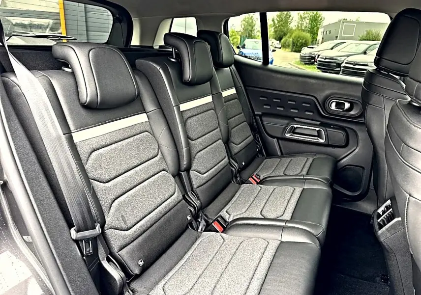 Vue latérale intérieure sur la 2e rangée de sièges individuels gris foncé du Citroën C5 Aircross 2025.
