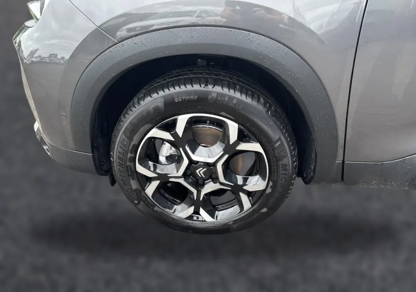 Gros plan sur la roue avant gauche du Citroën C5 Aircross gris platinium avec jante alu bicolore et pneus Michelin.
