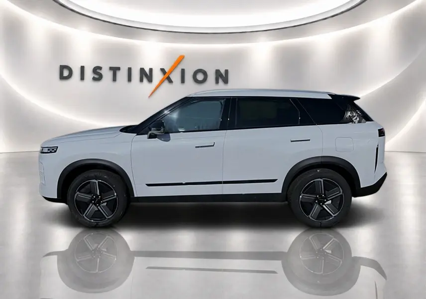 Vue de profil gauche du SUV JAECOO J7 blanc kaki avec toit noir et jantes alu noires dans un showroom lumineux.