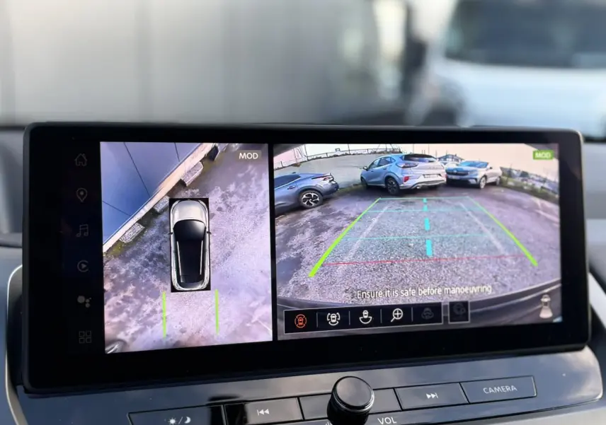 Écran intérieur montrant la caméra 360° et la vue arrière d'un Nissan Qashqai noir en stationnement.